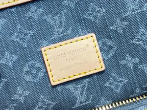 Louis Vuitton monogram denim canvas bag label with yellow stitching and gold zipper detailing