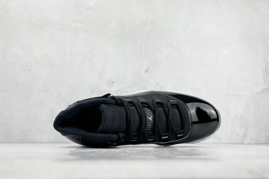 Nike Air Jordan 11 Retro Black patent leather and mesh sneakers with white midsole and black outsole