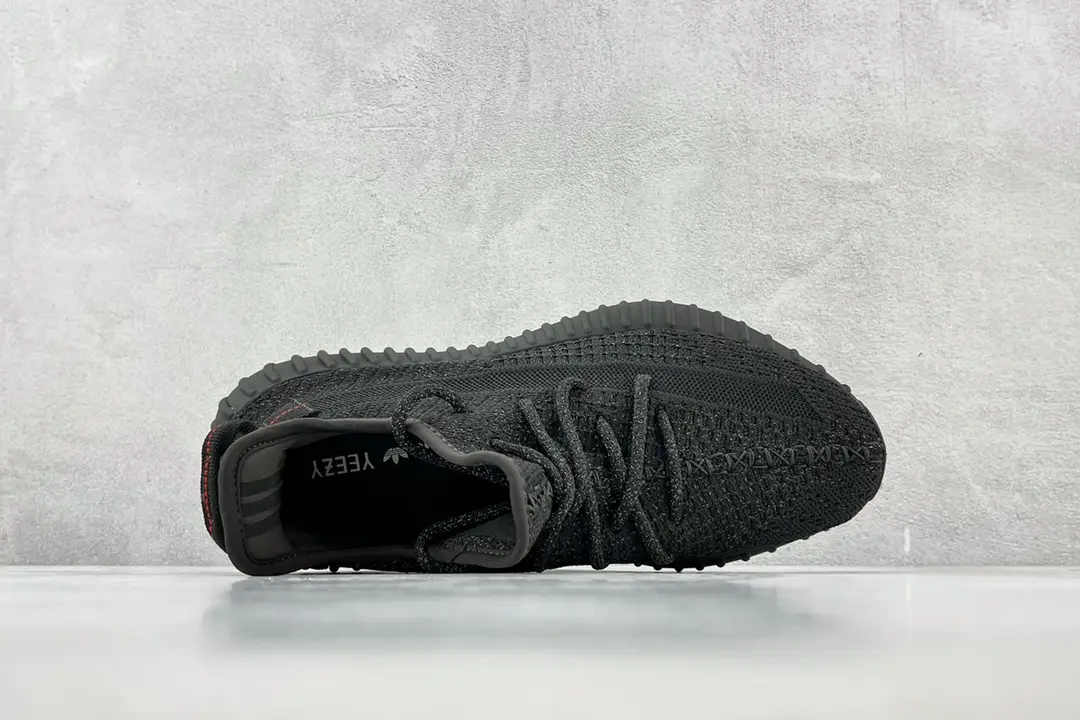 Adidas Yeezy Boost 350 V2 black Core knit sneakers with textured sole and signature red heel tab