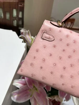Hermès Kelly 25 small pink ostrich leather handbag gold hardware handle close-up