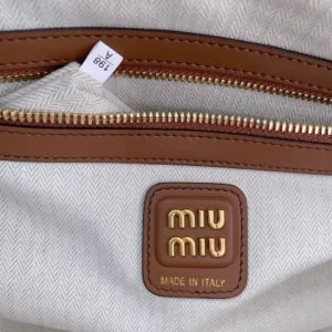Miu Miu bag medium tan leather trim beige herringbone canvas with gold logo badge and zipper closure