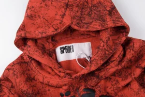 Repsgoat hoodie red spider web pattern cotton fabric with branded neck label close-up view
