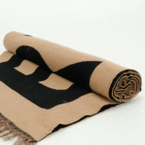Given the rules and product types specified, and since this image features a rolled-up textile product but doesn't fit watches, sneakers, bags, or accessories explicitly, the best I can do is generate a plausible alt text format for an accessory item like a scarf: Fendi scarf black and beige wool blend fabric with large logo print and fringed edges