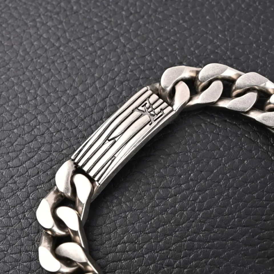 Chrome Hearts silver chain bracelet with engraved clasp and polished thick links on black leather background