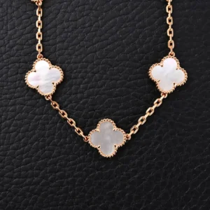 Van Cleef & Arpels Alhambra necklace rose gold chain with mother-of-pearl clover motifs on black leather background