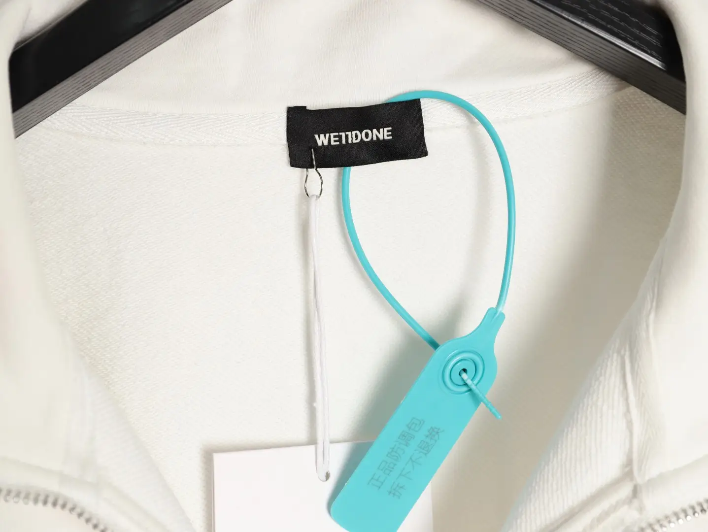 WET1DONE clothing white cotton zip-up jacket with black branded collar label and turquoise security tag